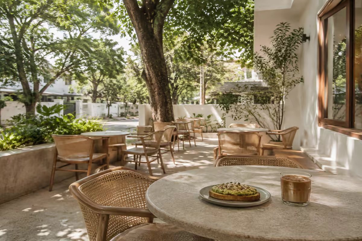Avocado toast and iced coffee in a leafy neighbourhood cafe courtyard in HSR Layout